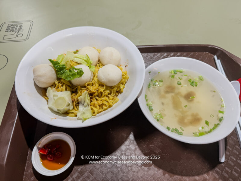 a bowl of noodles and meatballs on a tray