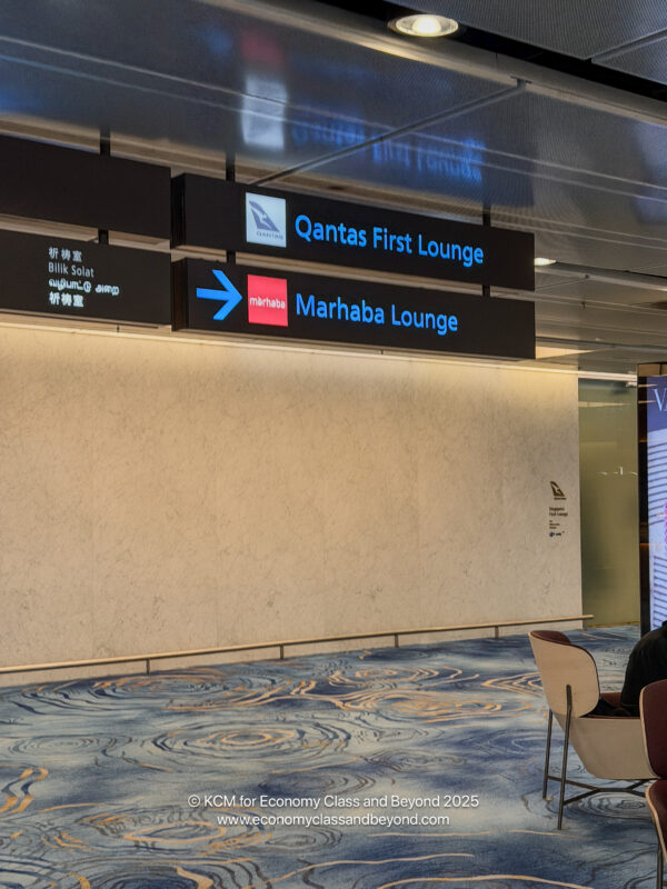 a man sitting in chairs in front of a sign