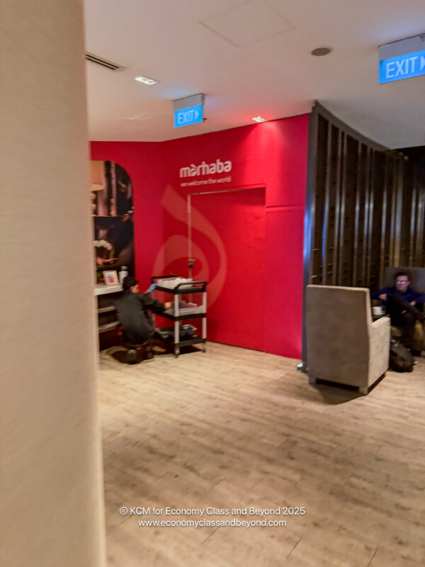 a room with a red wall and a man sitting on a chair