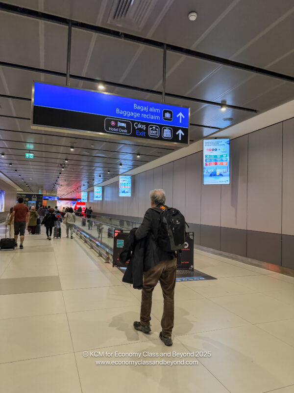 a man walking in a hallway with luggage