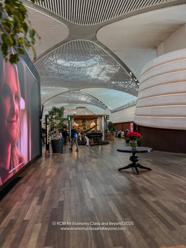 a large room with a large screen and people walking around