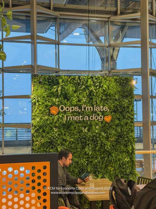 a man sitting at a table in front of a green wall