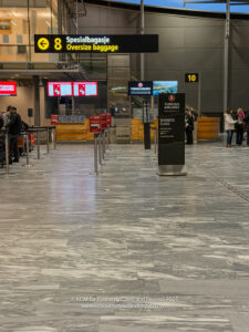 people in an airport with people waiting for their luggage