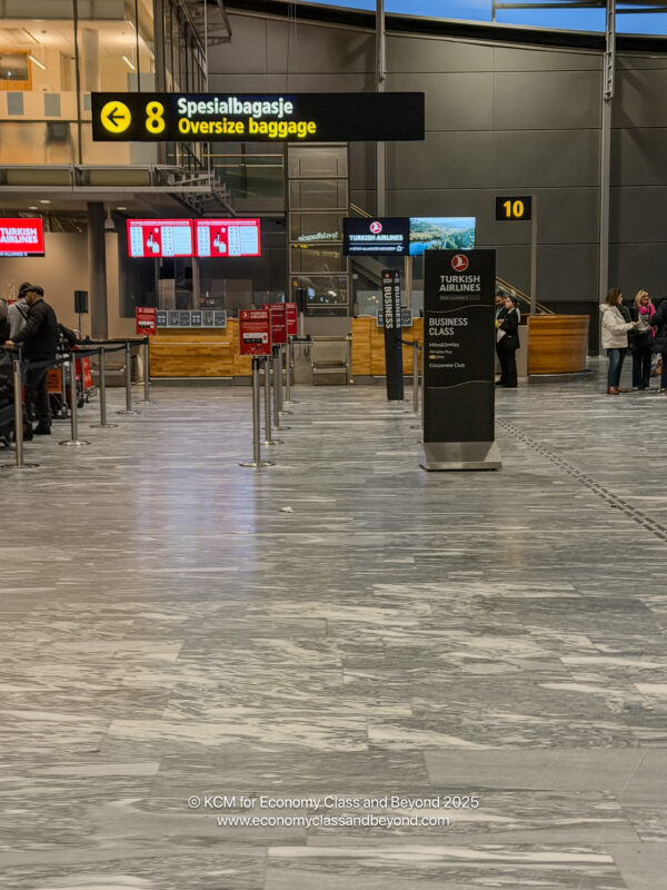 people in an airport with people waiting for their luggage
