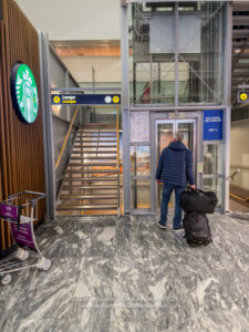 a man with luggage in front of a glass door