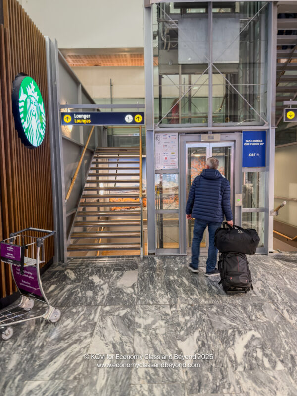 a man with luggage in front of a glass door