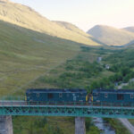 a train on a bridge over a river
