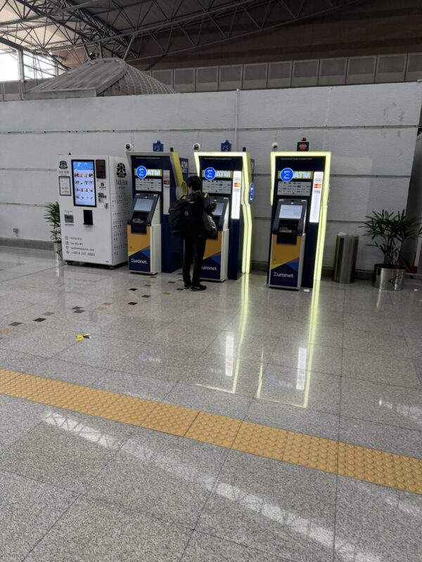 a person standing in front of a row of machines
