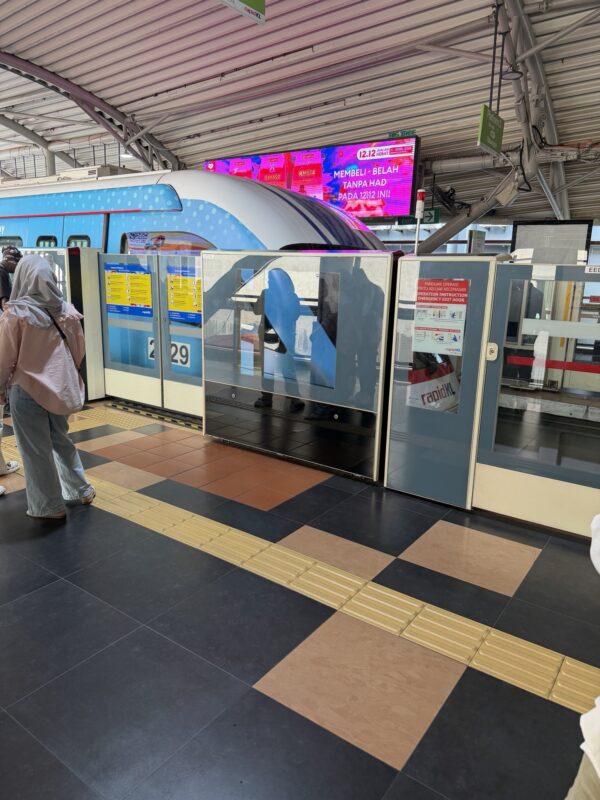 a train station with a train and a woman standing in front of it