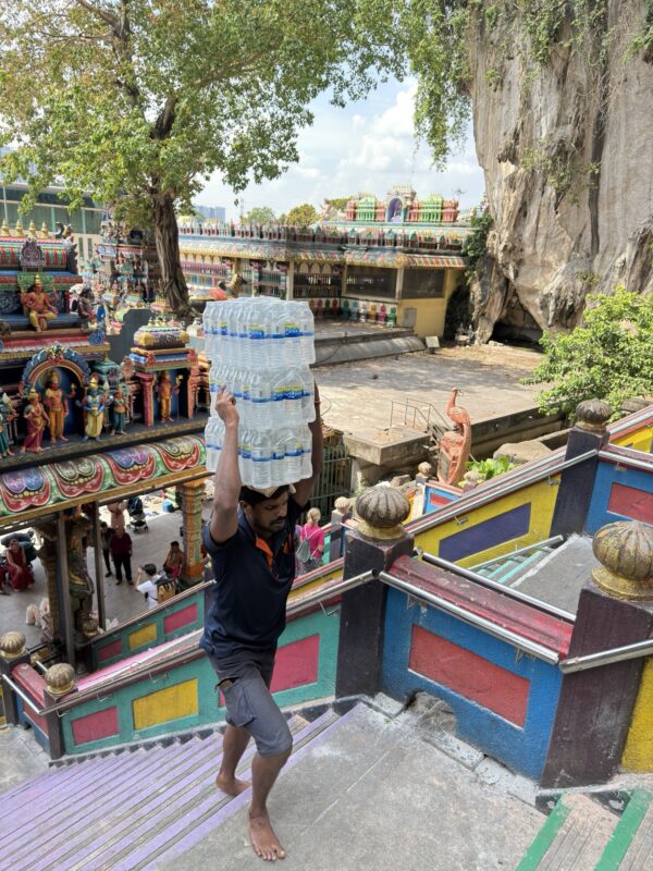 a man carrying water bottles on his head