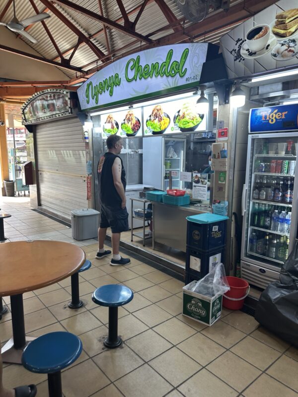 a man standing in front of a food stand