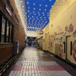 a brick walkway with lights over it