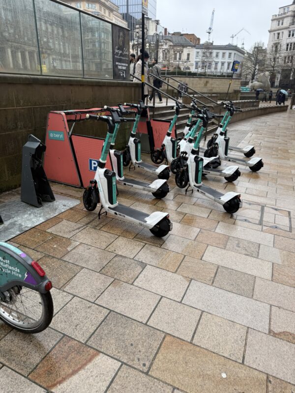 a group of scooters parked on a sidewalk
