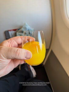 a hand holding a glass of orange juice