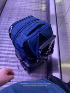 a blue backpack on a luggage carousel