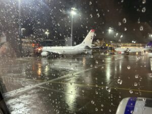 a plane parked on a wet tarmac at night