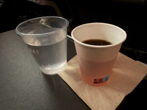 a plastic cup and a glass of liquid on a napkin