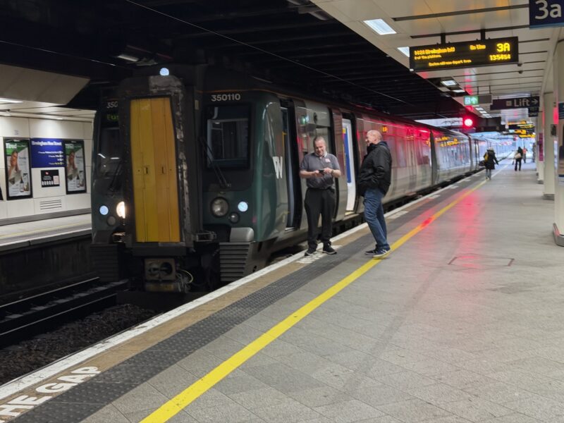 a group of people standing next to a train