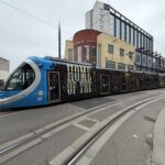 a blue train on a street