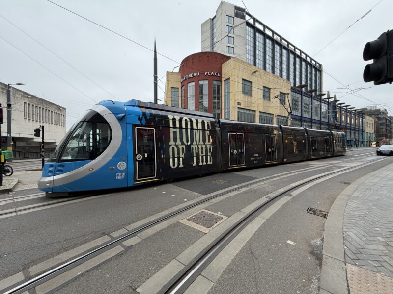 a blue train on a street