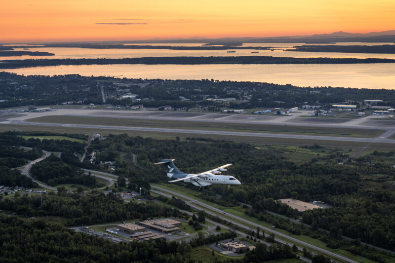 Heart Aerospace’s X1 demonstrator flies above Plattsburgh, New York, at sunrise during its first flight, with Lake Champlain and Vermont’s Green Mountains beyond, in August 2026 - Image, Heart Aerospace